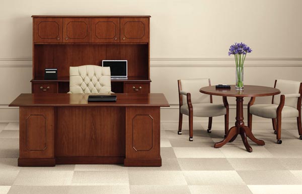 Executive traditional desk with kneehole credenza and storage hutch with doors. Matching conference table on right.