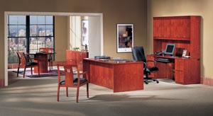 Chambers executive suite consisting a double pedestal desk, computer credenza, storage hutch, round conference table with chairs and two two drawer lateral files shown in Light Cherry