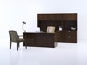 Bow Top Desk sits in front of storage wall shown in Shaker Cherry laminate with Soft edge and Axis pulls