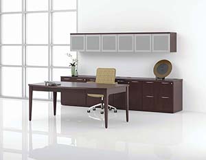 revolve Executive Table Desk. 24” Deep Lateral File Pedestals, 24” Deep Closed Bookcases, Rectangular Worksurfaces, Hanging Cabinet and Modular Cabinet Top. Shown in Espresso on Cherry with Butterfly edge and Slot pulls in Matte Chrome